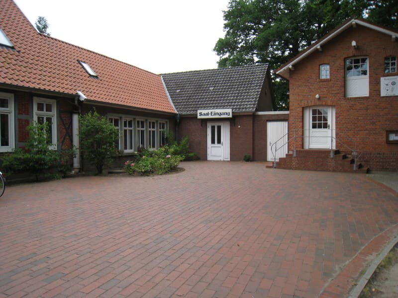 Der gepflasterte Hof vor dem Heimathaus mit seinen roten Backsteingebäuden.