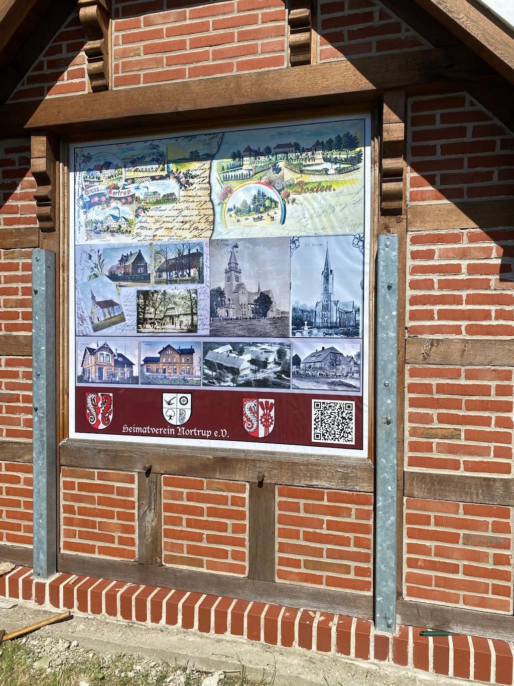 Schautafel mit alten Ansichten aus Nortrup in einem Backsteinrahmen.