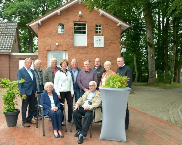 Der Vorstand 2018 als Gruppe vor dem Heimathaus, einige sitzend, die anderen dahinter stehend.